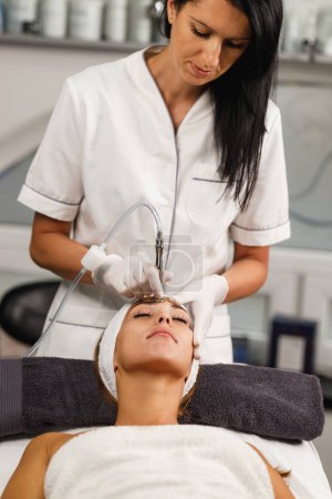 Photo for Shot of a beautiful young woman on a microdermabrasion facial treatment at the beauty salon. - Royalty Free Image