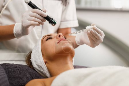 Foto de Foto de una hermosa mujer joven en un tratamiento de mesoterapia facial sin aguja en el salón de belleza. - Imagen libre de derechos