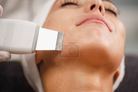 Téléchargez les photos : Tournage d'une belle jeune femme sur un traitement facial ultrasonique au salon de beauté. - en image libre de droit