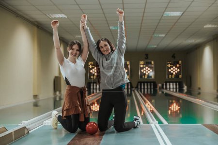 Téléchargez les photos : Deux amies joyeuses qui s'amusent au bowling club. - en image libre de droit