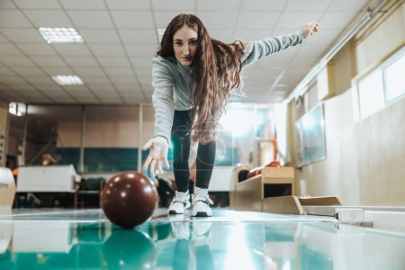 Téléchargez les photos : Tourné d'une jolie fille jetant la boule de bowling. - en image libre de droit