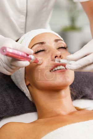 Photo for Shot of a beautiful young woman on a facial dermapen micro-needling treatment at the beauty salon. - Royalty Free Image