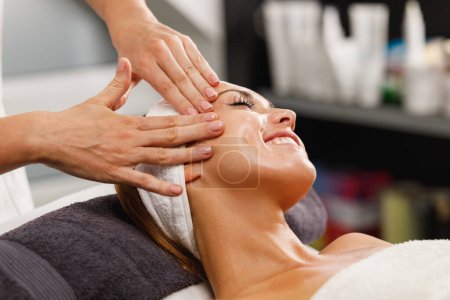 Photo for Shot of a beautiful young woman enjoying face massage at the beauty salon. - Royalty Free Image
