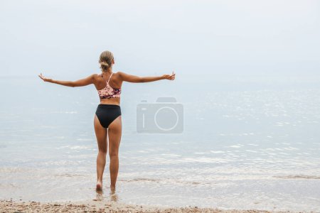 Foto de Linda chica adolescente sonriente disfrutando en la playa. Ella se divierte en el agua del mar y disfruta de vacaciones. - Imagen libre de derechos
