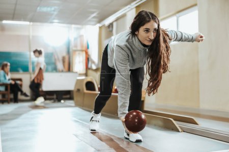 Photo for Shot of a cute young woman throwing the bowling ball. - Royalty Free Image