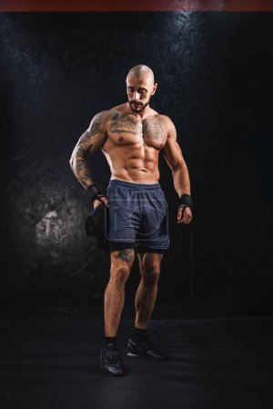 Téléchargez les photos : Prise de vue d'un jeune bodybuilder musculaire montrant ses muscles parfaits tout en se reposant après le travail à la salle de gym. - en image libre de droit