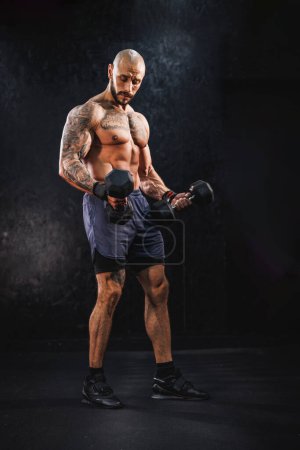 Photo for Shot of a muscular bodybuilder doing hard training with a dumbbell at the gym. - Royalty Free Image