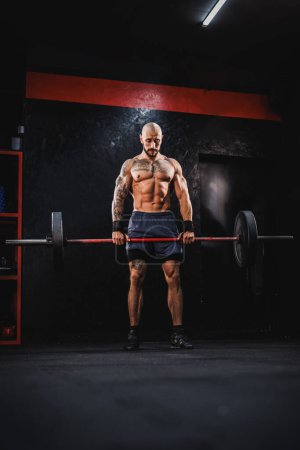 Photo for Shot of a young fitness man practicing deadlift with barbell at the gym. - Royalty Free Image