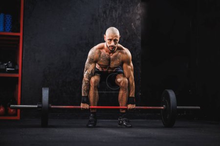 Photo for Shot of a young fitness man practicing deadlift with barbell at the gym. - Royalty Free Image
