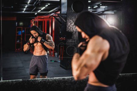 Téléchargez les photos : Prise de vue d'un jeune bodybuilder musclé montrant son pack de six parfait devant un miroir dans la salle de gym. - en image libre de droit