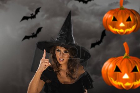 Foto de Retrato de una atractiva joven vestida con disfraces de bruja lista para la fiesta de Halloween. - Imagen libre de derechos