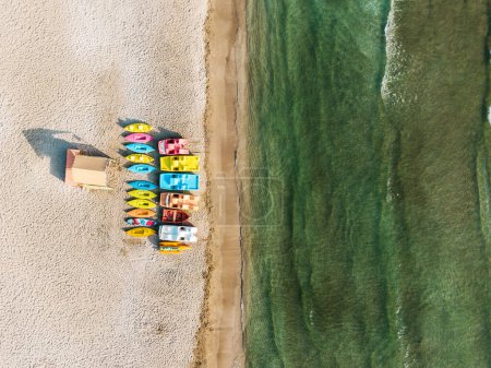 Photo for Aerial shot of a beautiful sea lagoon at hot summer day with line of colorful canoes on a sandy beach. - Royalty Free Image