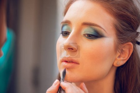 Foto de Primer plano de un maquillador que está listo para aplicar maquillaje a los labios de una hermosa joven
. - Imagen libre de derechos