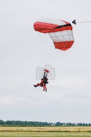 Téléchargez les photos : Parapente tandem atterrissant sur un terrain après un bon vol. - en image libre de droit