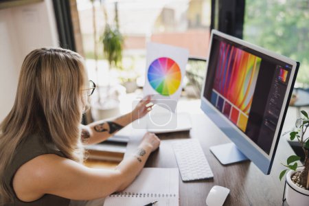 Téléchargez les photos : Jeune femme créative travaillant sur ordinateur dans son studio à la maison. - en image libre de droit