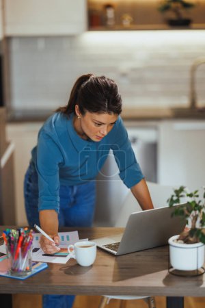 Téléchargez les photos : Jeune femme d'affaires travaillant sur ordinateur portable à partir de son bureau à domicile. - en image libre de droit