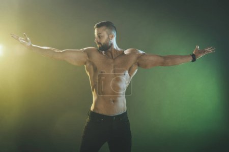 Foto de Foto de un joven musculoso culturista mostrando sus músculos perfectos mientras posaba después de hacer ejercicio. - Imagen libre de derechos