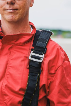 Foto de Primer plano del traje de paracaidista con cinturones abrochados mientras se prepara para saltar en tándem, empacar y comprobar el equipo. - Imagen libre de derechos