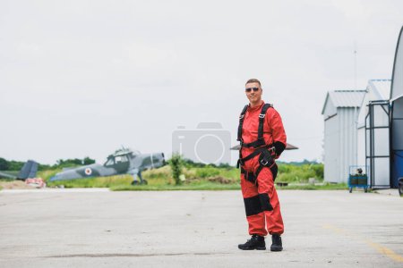 Foto de Paracaidista posando en un aeropuerto, preparándose para saltar en paracaidismo en tándem. - Imagen libre de derechos