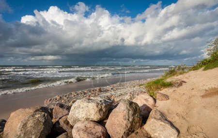 Foto de Nublado cielo mar playa y piedras en las dunas - Imagen libre de derechos