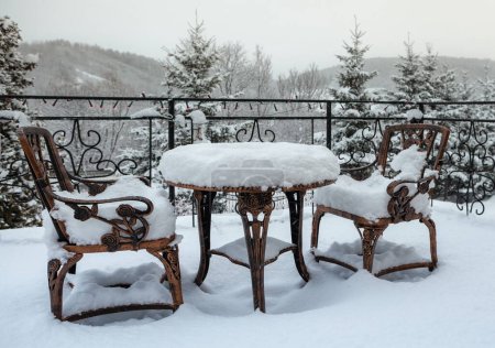 Foto de Mesa y sillas en una terraza de invierno cubierta de nieve - Imagen libre de derechos
