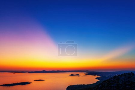 Téléchargez les photos : Coucher de soleil sur la mer avec vue sur les îles - en image libre de droit
