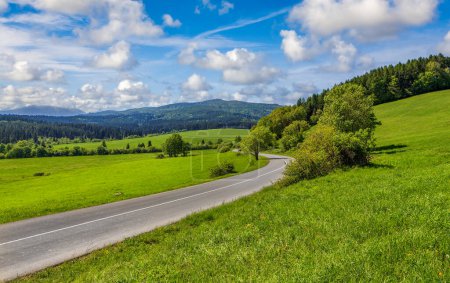 Téléchargez les photos : Route sinueuse de montagne dans une vallée verdoyante au printemps - en image libre de droit