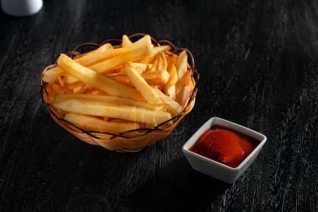 Téléchargez les photos : Vue rapprochée de belles frites délicieuses sur fond sombre - en image libre de droit