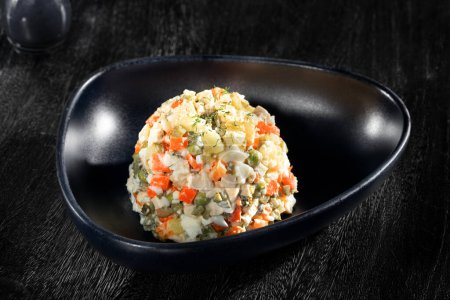 Téléchargez les photos : Vue rapprochée de belle salade russe délicieuse sur fond sombre - en image libre de droit