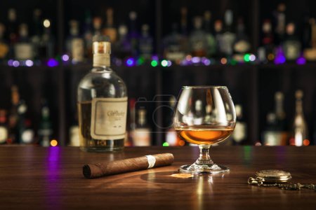 Foto de ¡No hay logotipos ni marcas! ¡AUTO Hizo ETIQUETAS! vista de cerca de la botella de whisky, cigarro y vidrio en la parte posterior del color. - Imagen libre de derechos