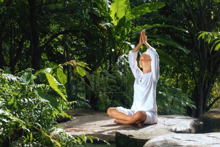 Téléchargez les photos : Portrait de jeune femme pratiquant le yoga dans un environnement tropique - en image libre de droit