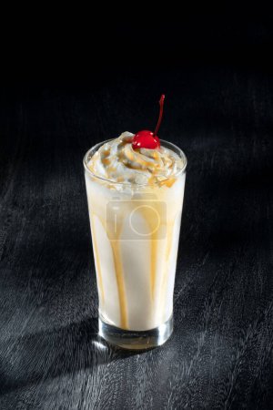 Téléchargez les photos : Vue du joli milkshake à la crème glacée au lait sur fond gris - en image libre de droit