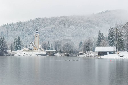 Téléchargez les photos : Scenic winter landscape of Bohinj lake in Gorenjska with old bridge and Church, Julian alps, Slovenia - en image libre de droit