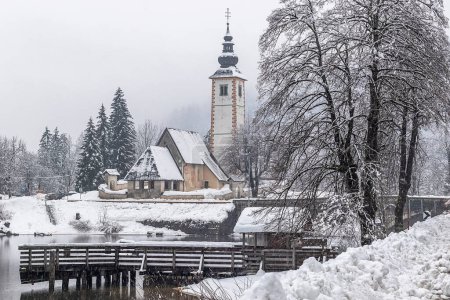 Téléchargez les photos : Scenic winter landscape of Bohinj lake in Gorenjska with old bridge and Church, Julian alps, Slovenia - en image libre de droit