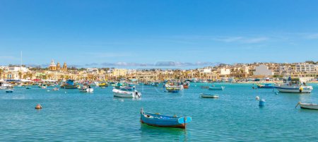 Téléchargez les photos : Des bateaux maltais flottent dans le port de Marsaxlokk, à Malte. les bateaux de pêche sont décorés avec l'oeil d'Osiris pour assurer la sécurité des pêcheurs en mer - en image libre de droit