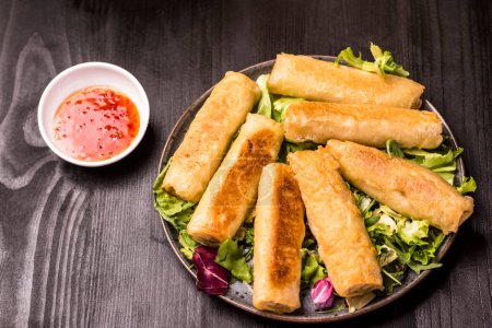 Photo for Chinese style meal - gyoza dumplings, spring rolls and rice with chicken - Royalty Free Image