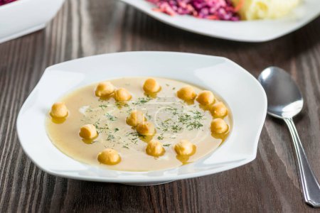 Téléchargez les photos : Soupe aux oignons aux petits pois - assiettes blanches sur une table en bois - en image libre de droit