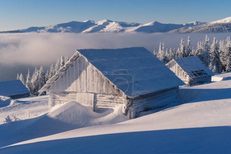Foto de Paisaje matutino de invierno con heladas en una cabaña de montaña - Imagen libre de derechos