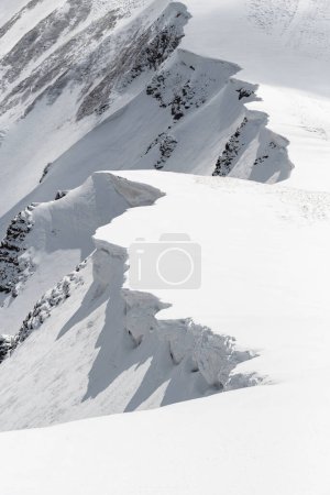 Téléchargez les photos : Corniches de neige dangereuses sur la chaîne de montagnes - en image libre de droit