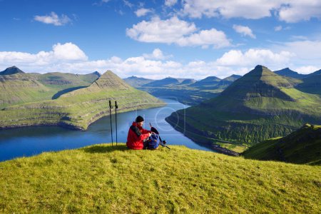 Téléchargez les photos : Touriste avec un sac à dos au sommet de Hvithamar Hill Surplombant Funningsfjordur Fjord, Eysturoy Island, Îles Féroé - en image libre de droit