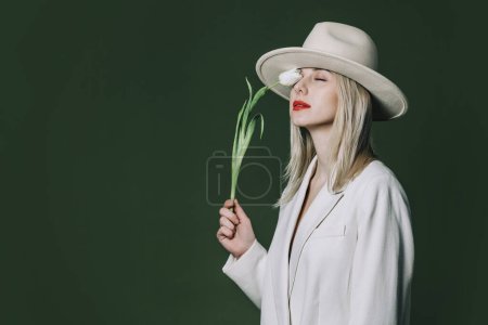 Téléchargez les photos : Stylish blond hair woman with tulip flower on green background - en image libre de droit