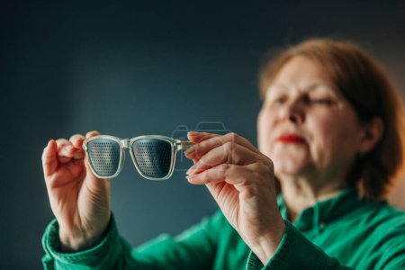 Téléchargez les photos : Femme âgée portant des lunettes spéciales pour la formation des yeux - en image libre de droit