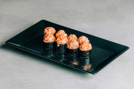Photo for Sushi rolls with salmon and caviar on black plate on gray background - Royalty Free Image