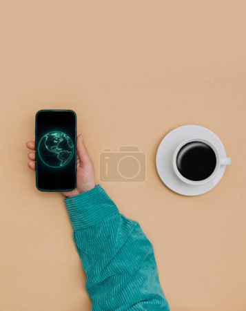 Foto de Pov view on female hands with smartphone next to notebook and cup of coffee on brown background - Imagen libre de derechos
