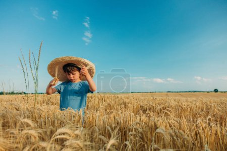 Photo for Little boy in hat in wheat field in summer time - Royalty Free Image