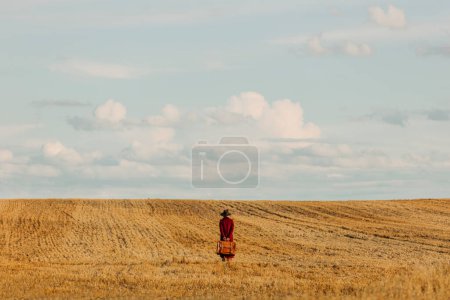 Photo for Stylish woman in vintage hat red coat with suitcase on wheat field in countryside - Royalty Free Image