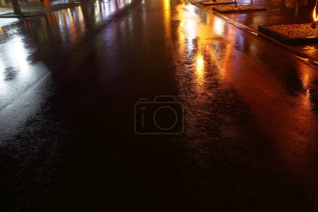 Téléchargez les photos : Vue de la rue humide de la ville la nuit - en image libre de droit