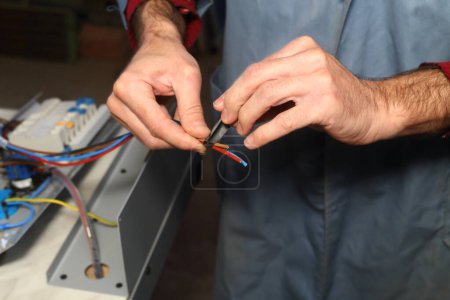 Foto de Un electricista trabaja en un dispositivo - Imagen libre de derechos