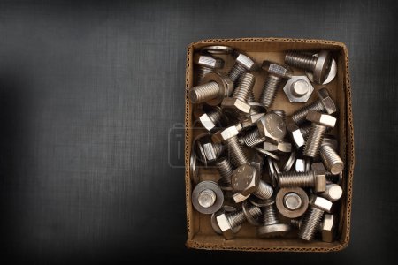 Photo for Bolts and shims in a cardboard box with space for text - Royalty Free Image