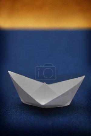 Foto de Barco de papel blanco sobre azul y oro - Imagen libre de derechos